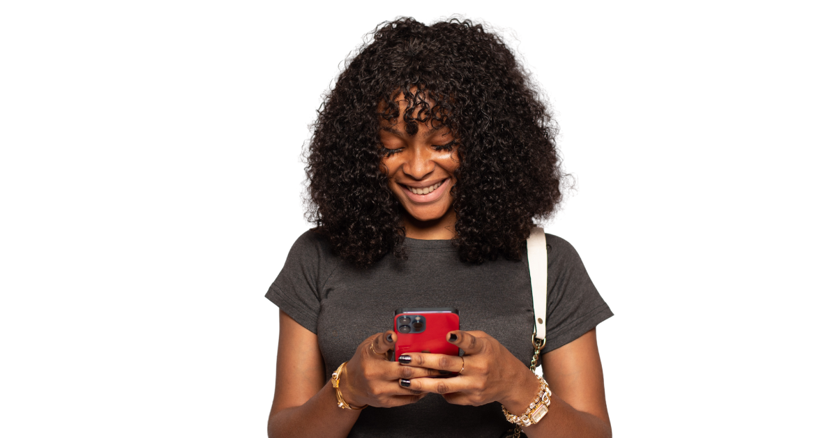 HPV vaccine near me - Smiling young Black woman with curly hair looking down at her mobile phone against a white background, searching for vaccination locations.